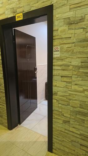 a elevator door in a building with a stone wall at رؤى القنفذة للشقق المخدومة in Al Qunfudhah