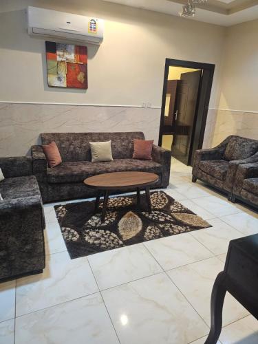 a living room with a couch and a table at رؤى القنفذة للشقق المخدومة in Al Qunfudhah