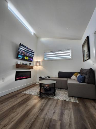 a living room with a couch and a tv at 2BR Detached Guesthouse - Free Parking -10 mins to YVR & Downtown in Vancouver