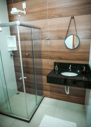 a bathroom with a sink and a mirror at Hotel Canaã in Ipirá
