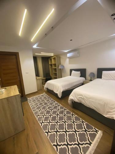 a hotel room with two beds and a rug at الحصرى Elhosary otel in 6th Of October