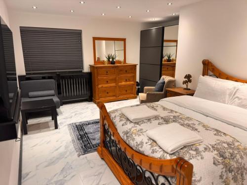 a bedroom with a large bed and a living room at Modern House Apartment Stratford E15 London - Sleeps 2 - 9, Fast Links to Central London, Near O2, Greenwich & Olympic Park, Child-Friendly Garden, Free Parking, Free WiFi in London