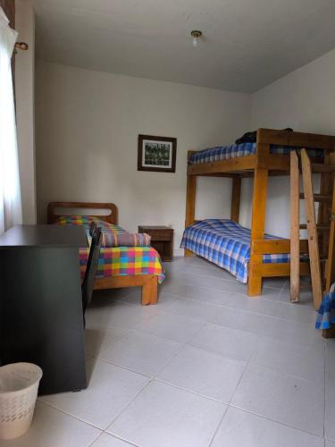 a room with two bunk beds and a table at Montaña Sanadora in Medellín
