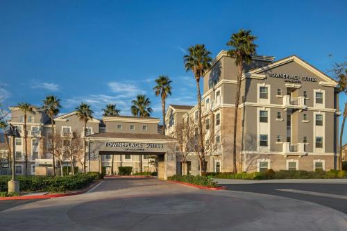 a large building with palm trees in front of it at TownePlace Suites by Marriott Ontario Airport in Rancho Cucamonga