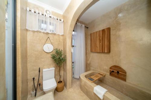 a bathroom with a tub and a toilet in it at Marram Villas Prime Location in Paje