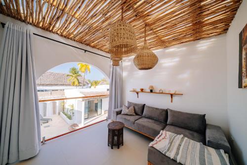a living room with a couch and a large window at Marram Villas Prime Location in Paje