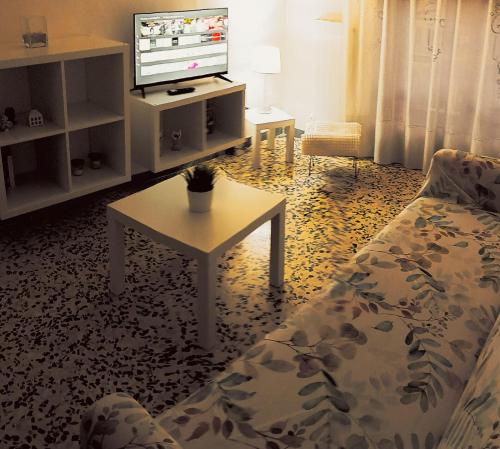 a living room with a couch and a table and a tv at Casa Lodi Casavacanze in Eboli