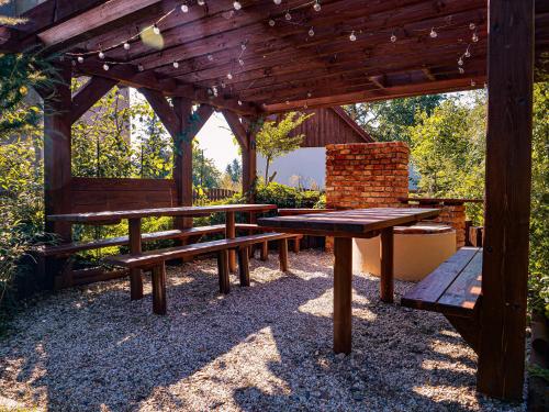 a picnic table and bench under a wooden pergola at Apartmány 13 Přízemí 1 in Seč