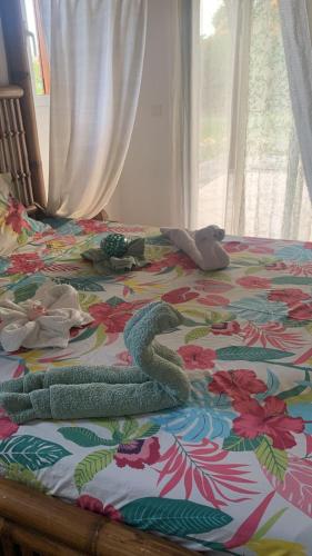 a bed with a colorful bedspread with dolls on it at Le Chalet des Rêves Ensoleillés in Saint-François