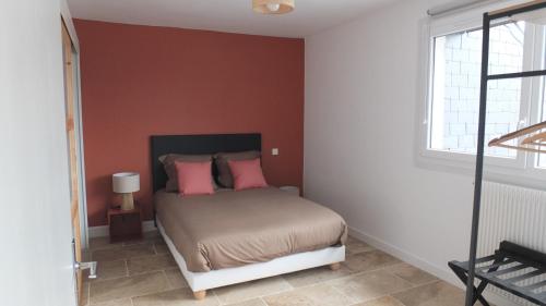 une chambre avec un lit avec des oreillers roses dans l'établissement APP Le Goury, à Valognes