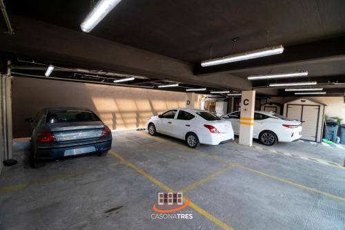 a parking garage with three cars parked in it at S03 SUITE CON CAMA KING SIZE Premium Frente al TEC CEM con Cocineta WiFi Balcón Parking Terraza 10 in Mexico City