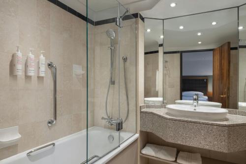 a bathroom with a tub and a sink and a shower at Leeds Marriott Hotel in Leeds
