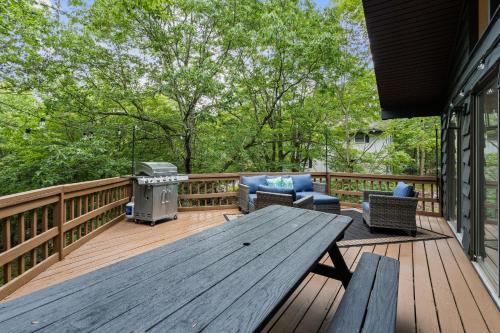 a wooden deck with a picnic table and a grill at Cabin in the Skye - 5 BDs Lake Harmony in Lake Harmony