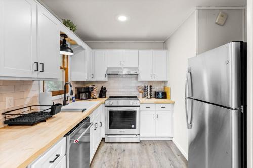 a kitchen with white cabinets and a stainless steel refrigerator at Cabin in the Skye - 5 BDs Lake Harmony in Lake Harmony