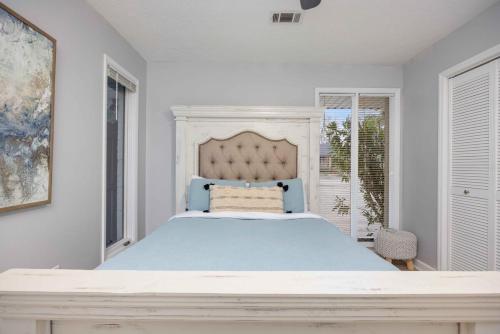 ein weißes Schlafzimmer mit einem blauen Bett und einem Fenster in der Unterkunft Serene Midtown Apartment 8 mi to Ft Moore in Columbus