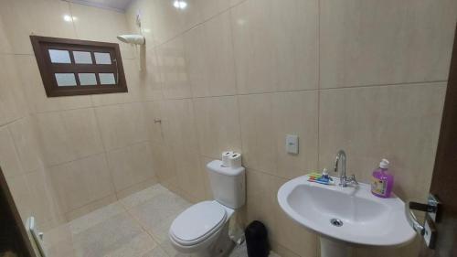a bathroom with a white toilet and a sink at Casa em Itapecerica da Serra com Conforto e Lazer in Itapecerica da Serra