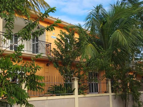 a yellow building with trees in front of it at Villa Myosotis in Trou aux Biches