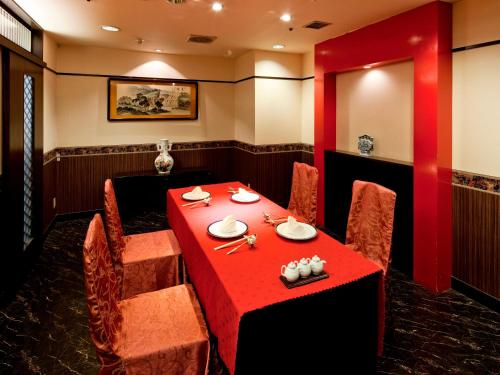 a dining room with a red table and chairs at Art Hotel Morioka in Morioka