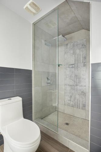 a bathroom with a toilet and a glass shower at La TUMU in Toronto