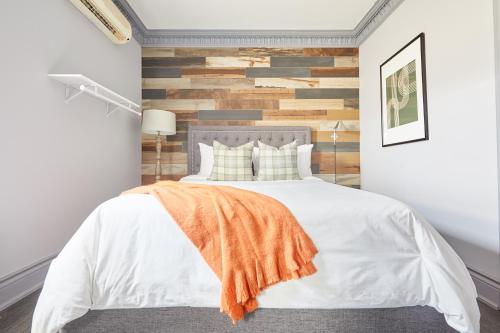 a bedroom with a bed with a wooden accent wall at La TUMU in Toronto