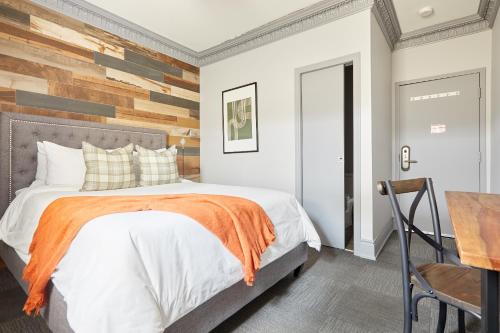 a bedroom with a bed and a wooden accent wall at La TUMU in Toronto