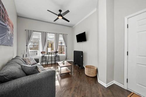a living room with a couch and a ceiling fan at Cozy 1 Bedroom Apt near Logan Sq in Chicago