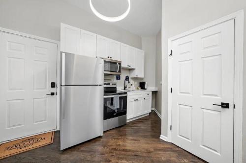 a kitchen with white cabinets and a white refrigerator at Cozy 1 Bedroom Apt near Logan Sq in Chicago