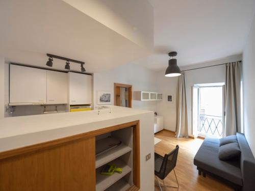 a kitchen with a counter and a living room at Spanish Steps, Suite Dominic, Strollingrome in Rome
