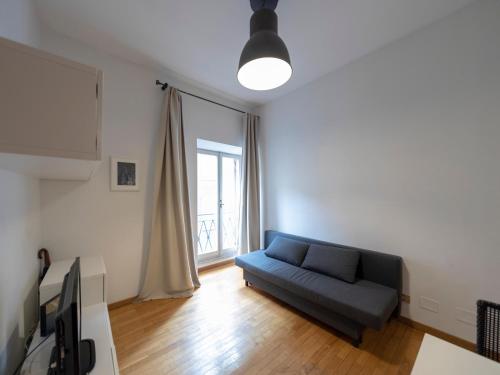 a living room with a blue couch and a window at Spanish Steps, Suite Dominic, Strollingrome in Rome