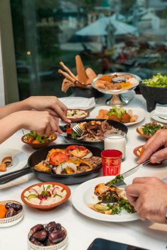 a table full of plates of food on a table at Sheraton Abu Dhabi Hotel & Resort in Abu Dhabi
