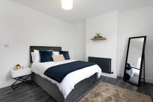 a bedroom with a large bed and a mirror at The Modern Retreat in Leicester