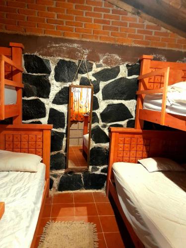 a room with three bunk beds and a mirror at Acogedora cabaña cerca de La Marquesa in San Pedro Atlapulco