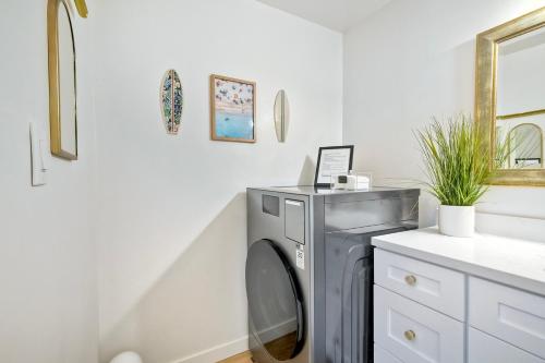 a washing machine in a laundry room next to a sink at La Costa Escape - Pool, BBQ, Gated Parking in Encinitas