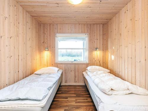two beds in a room with a window at 4 star holiday home in Idestrup in Marielyst