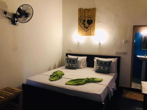 a bedroom with a bed with green towels on it at Sh li in Sigiriya