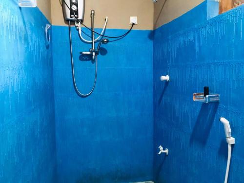 a blue bathroom with a shower with a blue wall at Sh li in Sigiriya