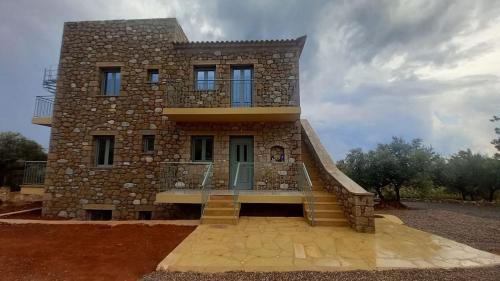 a large stone house with stairs in front of it at Marmaras Mani Houses in Riglia