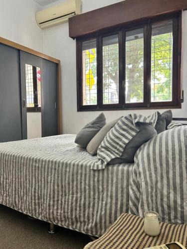 a bedroom with two beds with pillows and windows at La Sofia in Montevideo
