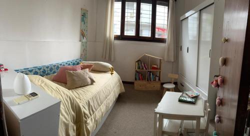 a small bedroom with a bed and a table at La Sofia in Montevideo