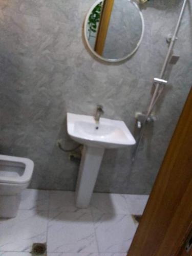 a bathroom with a sink and a mirror and a toilet at Flat 1 Block B Elizabeth Courts in Lagos
