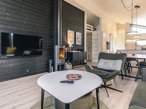 a living room with a white table and a fireplace at 9 person holiday home in Væggerløse-By Traum in Marielyst