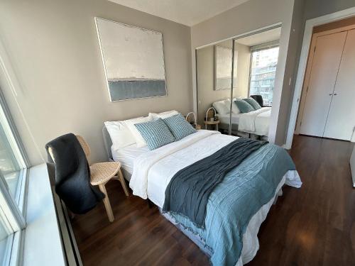 温哥华Modern spacious Apt plus Solarium and Den in Downtown Vancouver with Parking and Pool的一间卧室，里面有一张床、一把椅子和一扇窗户