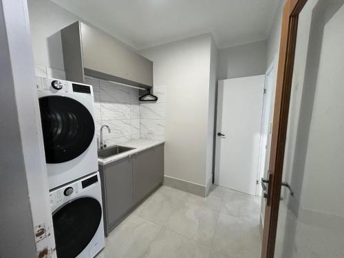 a kitchen with a washer and dryer and a sink at Allure Beach House - Formerly Sands on Moreton in Tangalooma