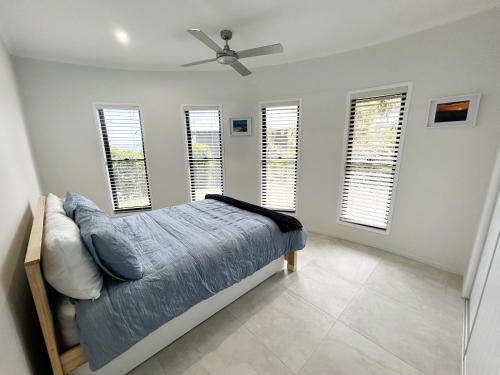 a bedroom with a bed and a ceiling fan at Allure Beach House - Formerly Sands on Moreton in Tangalooma
