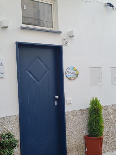 a blue door on a building with a potted plant at Maruzzé luxury room in Albori