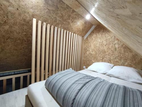 une chambre avec un lit et un mur en bois dans l'établissement Chez GL, à Couilly-Pont-aux-Dames