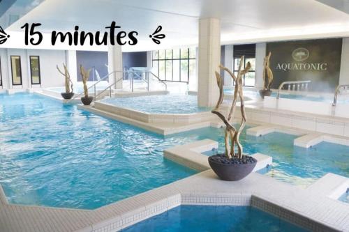 une grande piscine avec de l'eau bleue dans un immeuble dans l'établissement Chez GL, à Couilly-Pont-aux-Dames