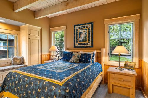 ein Schlafzimmer mit einem Bett und zwei Fenstern in der Unterkunft Metolius Cabin 7 in Camp Sherman