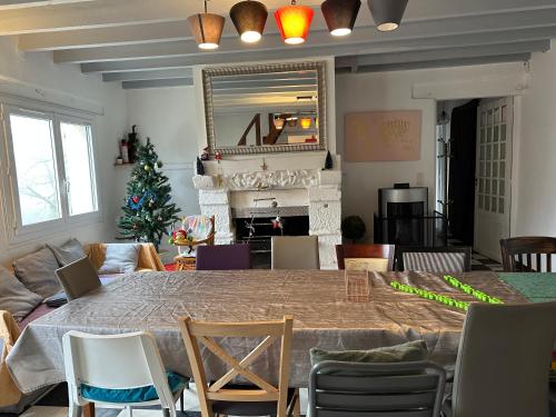 un salon avec une table et un sapin de Noël dans l'établissement House of birds, à Conie-Molitard
