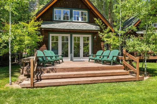 a wooden deck with chairs and a house at Metolius Cabin 5 in Camp Sherman